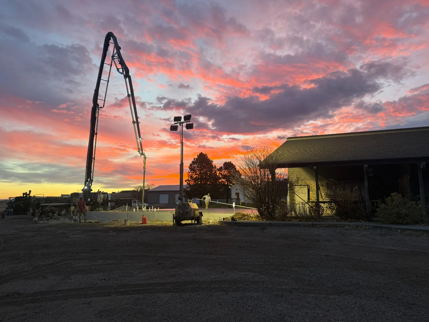 Concrete boom pump working against a vivid Montana sunrise